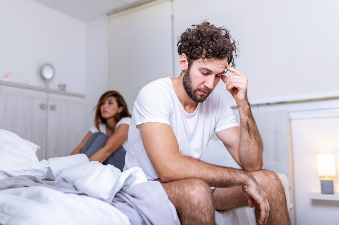 Beautiful girl and a frustrated man sitting in bed