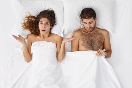 Frustrated male having erectile dysfunction, lying in bed with his wife