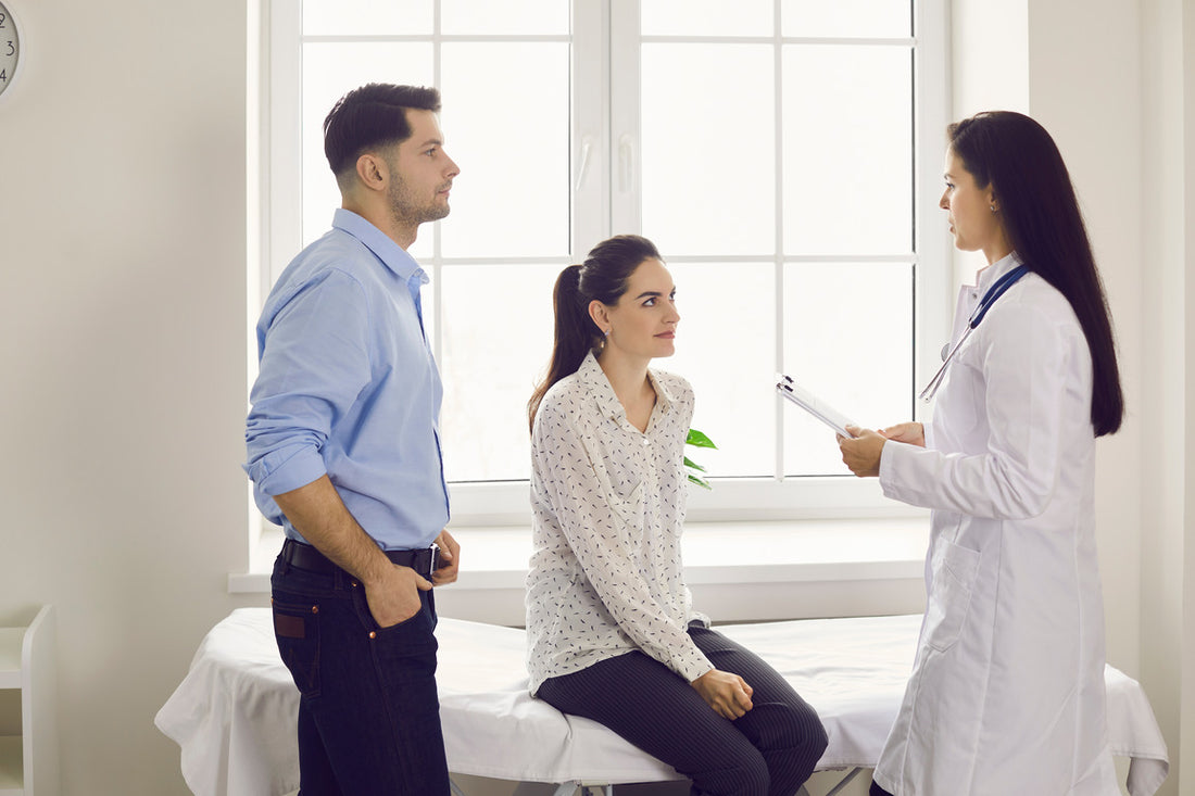 Happy couple planning pregnancy and seeing doctor at clinic.