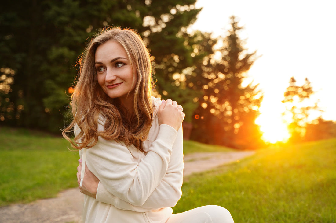 Happy girl hugging herself with love at sunset.