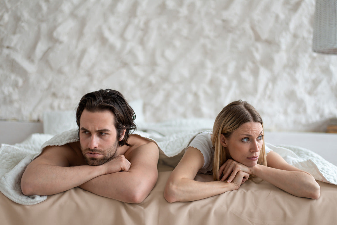 Stressed young couple lying in bed