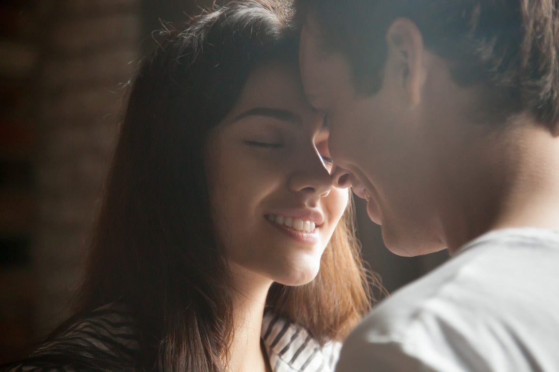 young couple standing face to face, having intimate moment